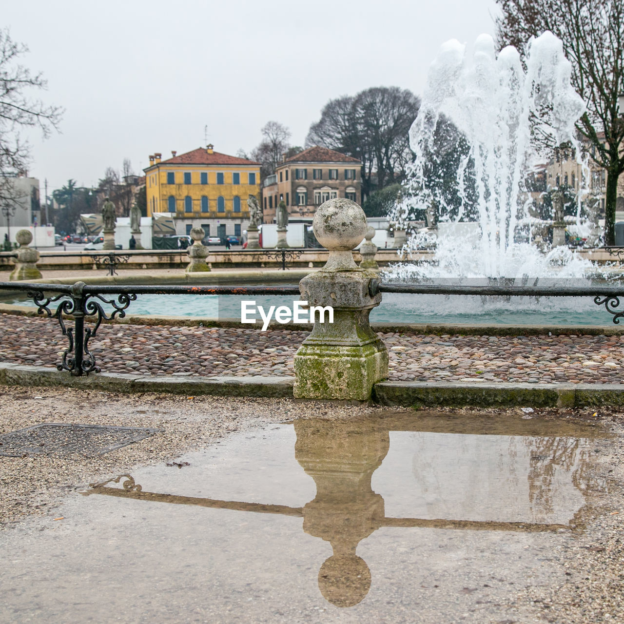 FOUNTAIN AGAINST LAKE AND BUILDINGS