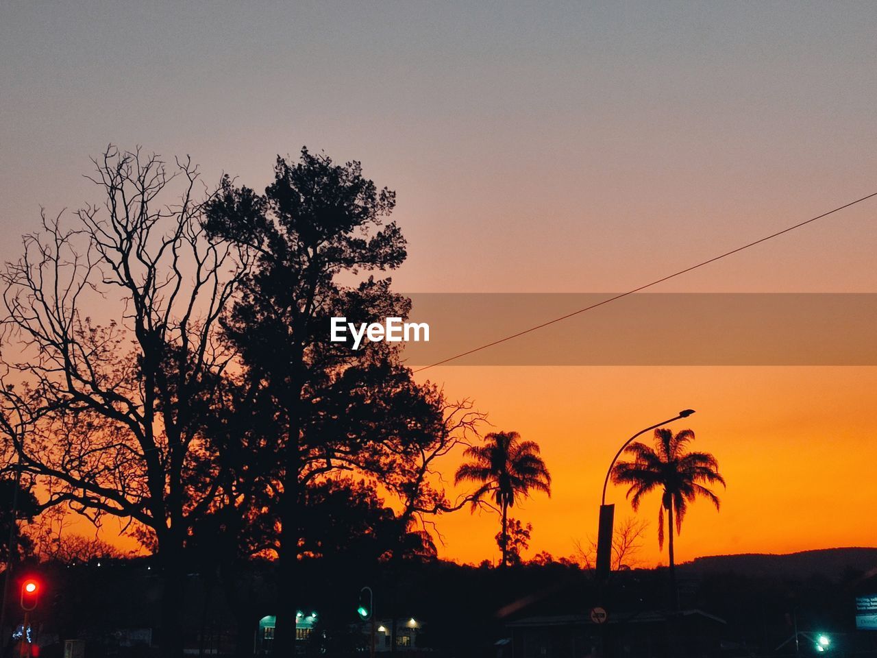 tree, sky, sunset, plant, dusk, evening, orange color, nature, silhouette, afterglow, car, no people, palm tree, beauty in nature, transportation, city, horizon, motor vehicle, mode of transportation, architecture, outdoors, cloud, street, travel destinations, tropical climate, illuminated, scenics - nature, tranquility, road, sun, travel
