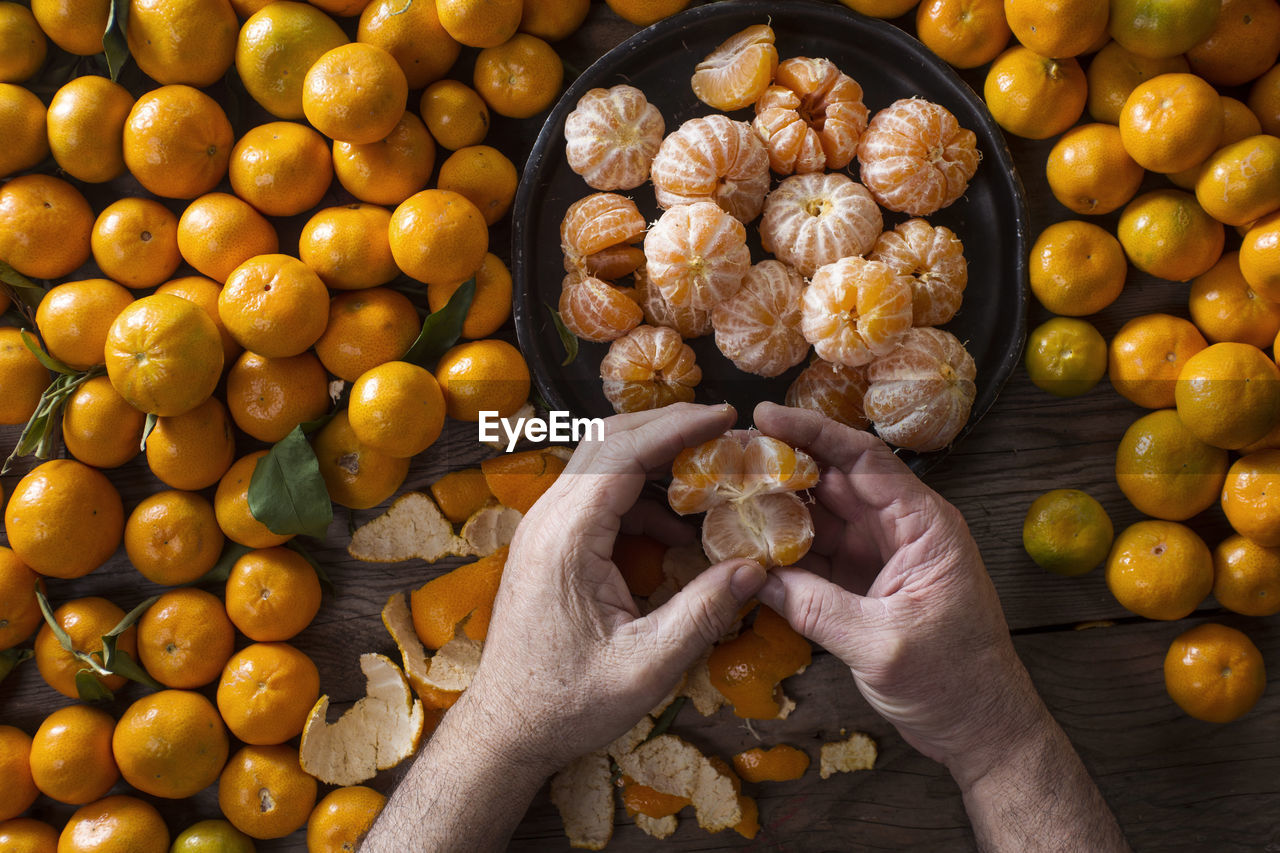 Cropped image of man holding orange