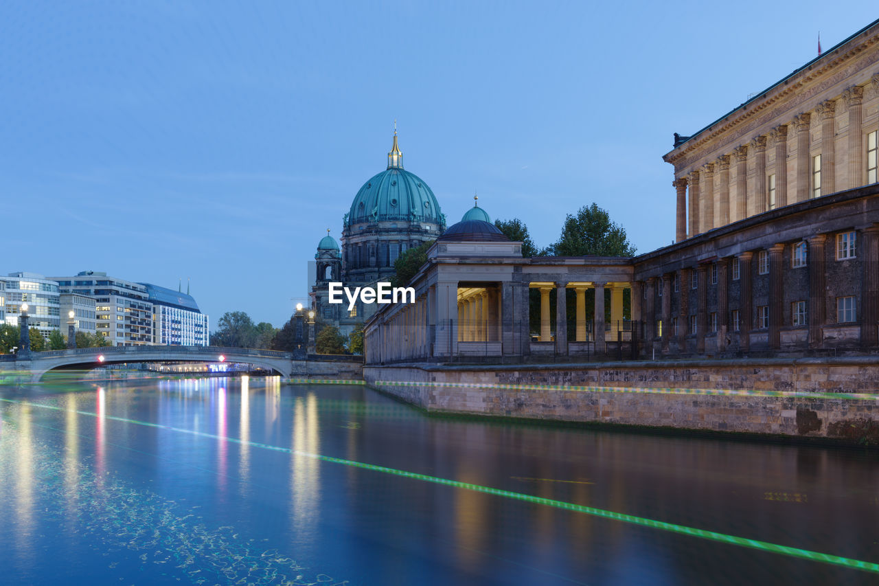 Illuminated bridge by berlin cathedral over river during sunset