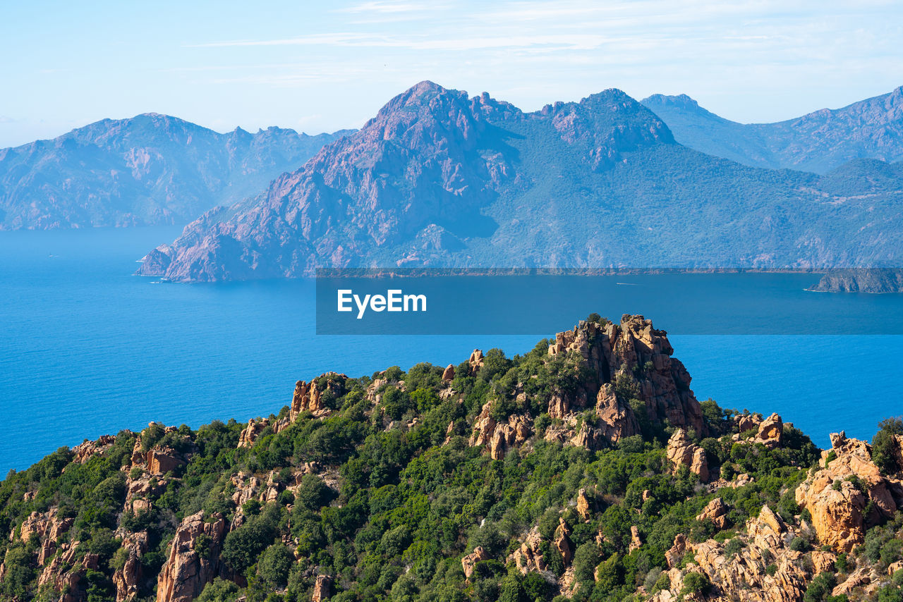 Scenic view of sea and mountains against sky