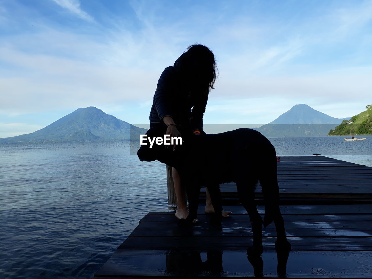 HORSE STANDING ON LAKE AGAINST SKY