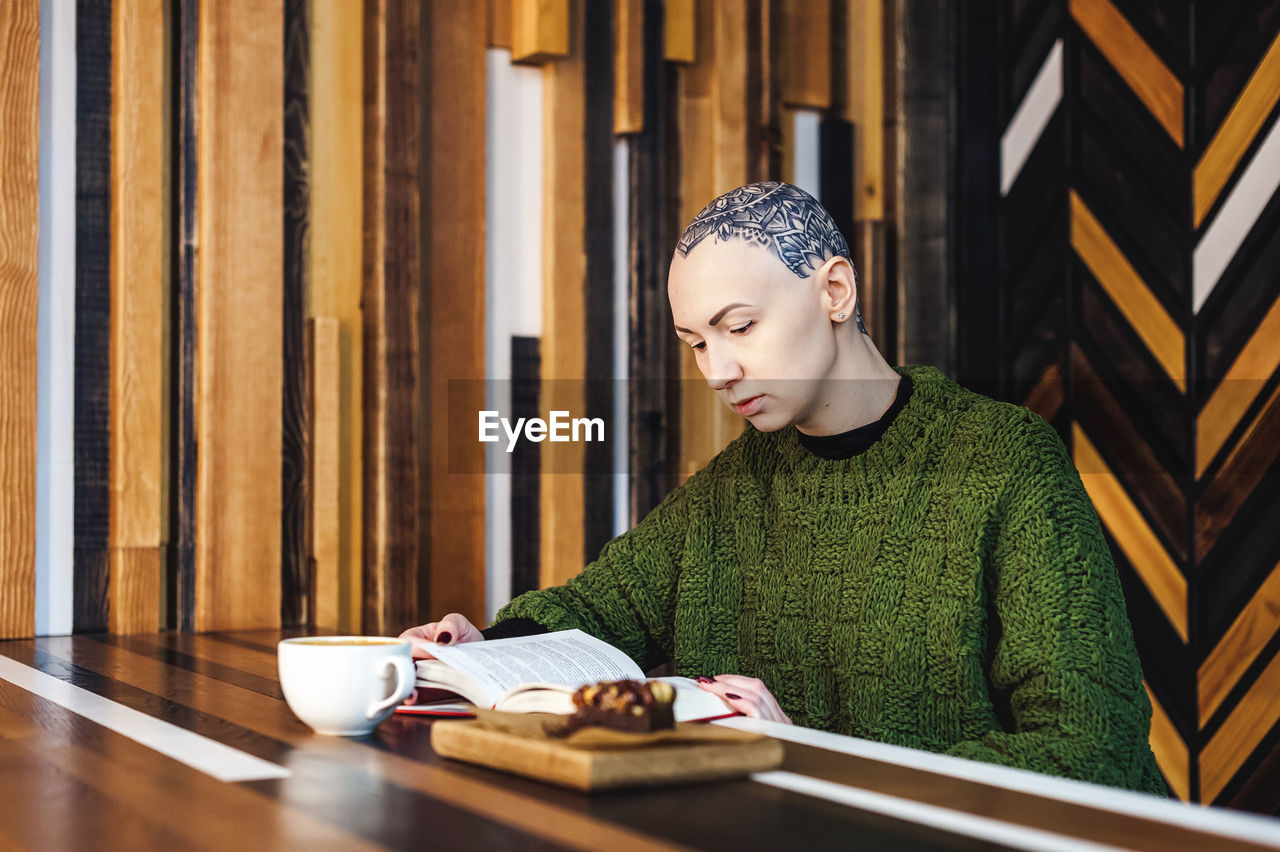 MID ADULT WOMAN WITH COFFEE CUP ON TABLE