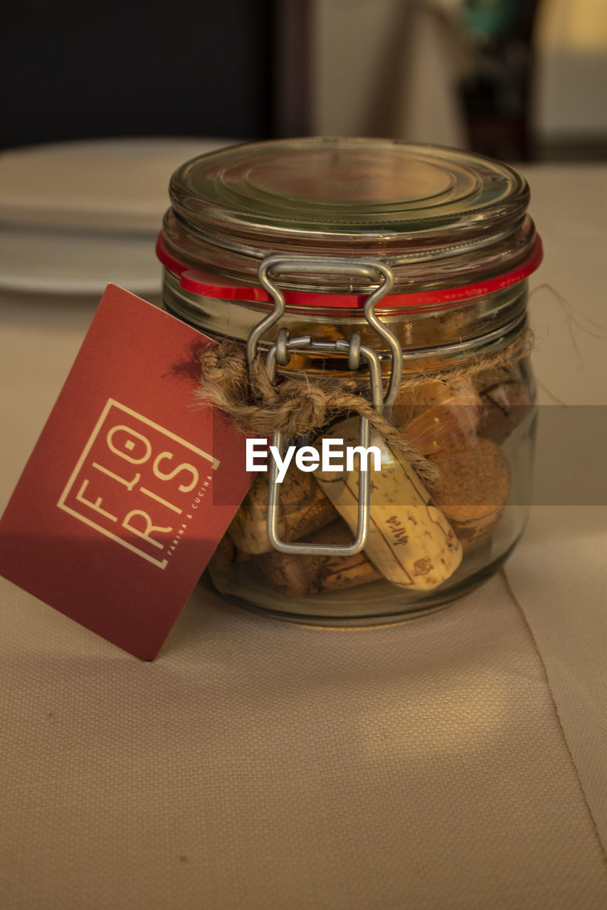 HIGH ANGLE VIEW OF SMALL DRINK IN JAR ON TABLE