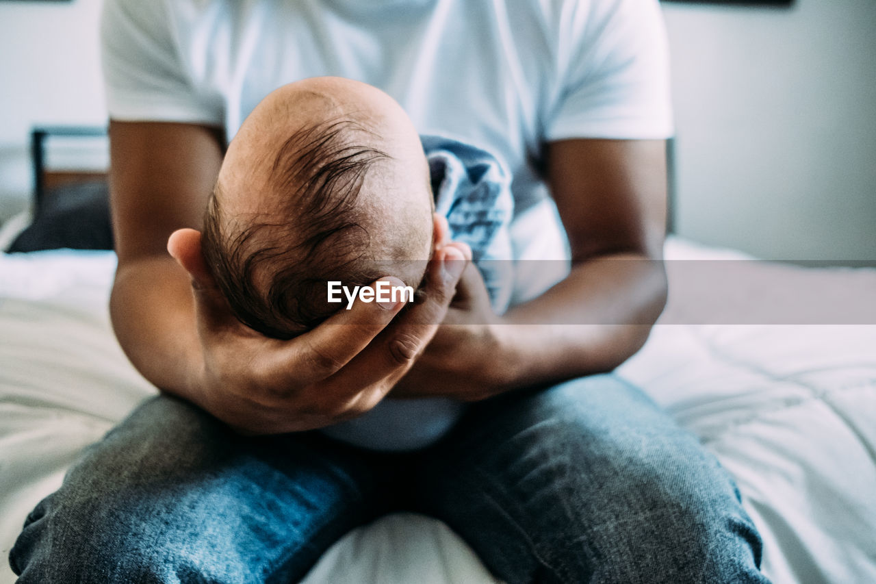 Center portrait of dad holding newborn baby