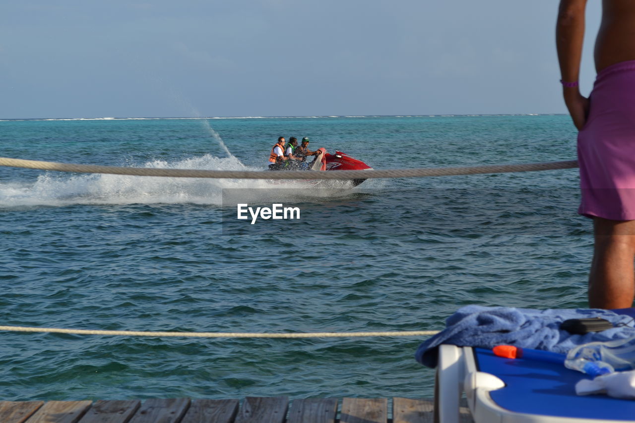 PEOPLE ON BOAT AGAINST SEA