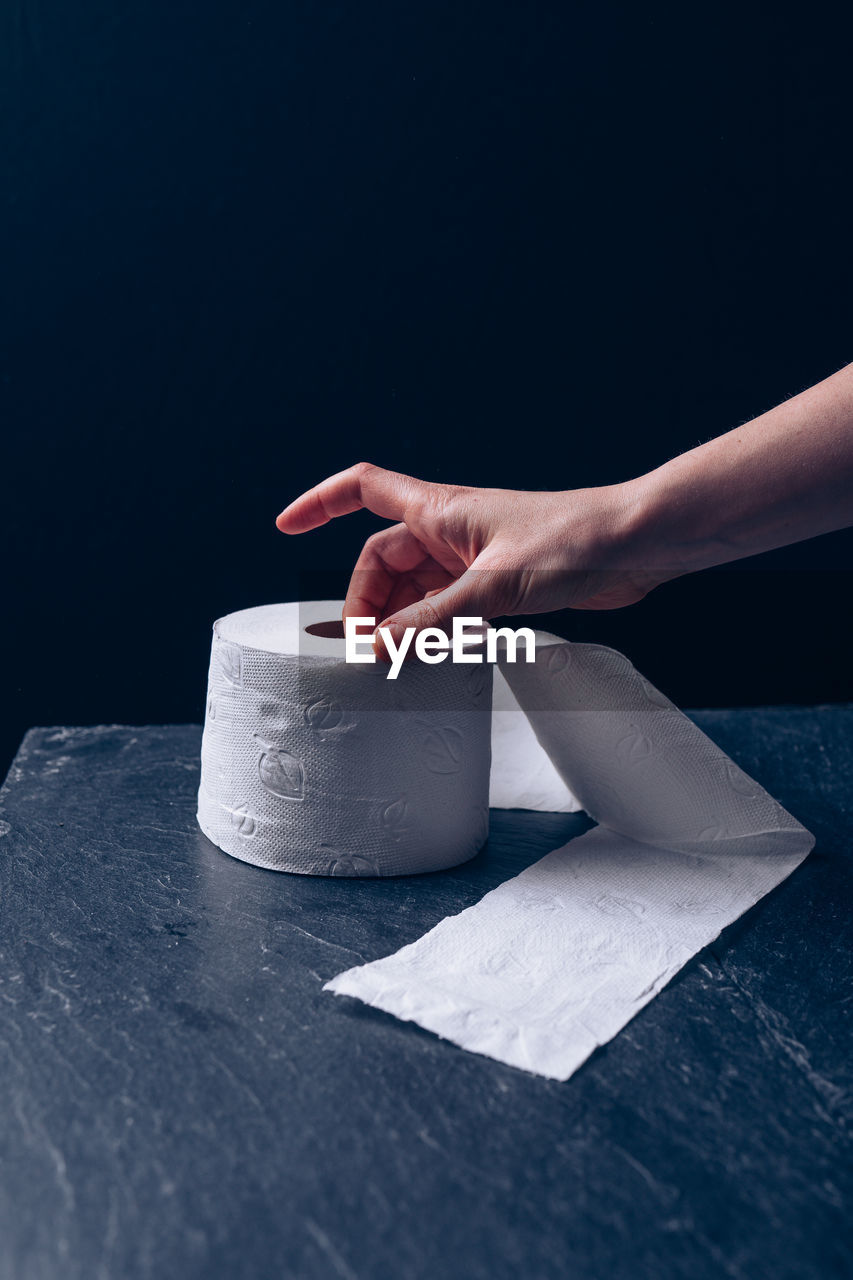 Woman takes the last roll of toilet paper during co-vid 19 pandemic outbreak, hand close-up.