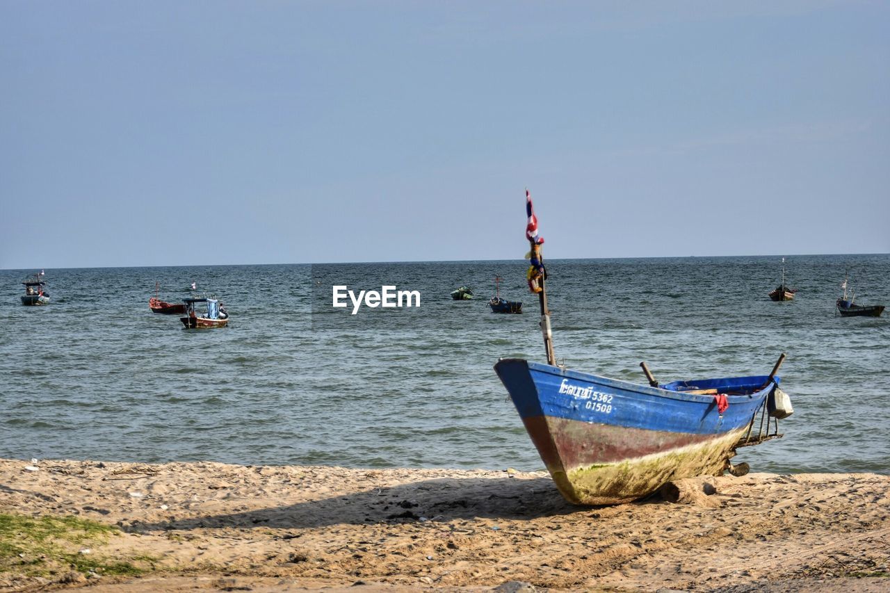 BOAT MOORED AT BEACH AGAINST CLEAR SKY