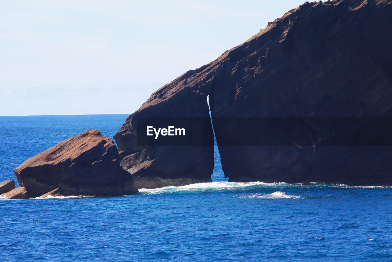 SCENIC VIEW OF SEA AGAINST ROCK FORMATION