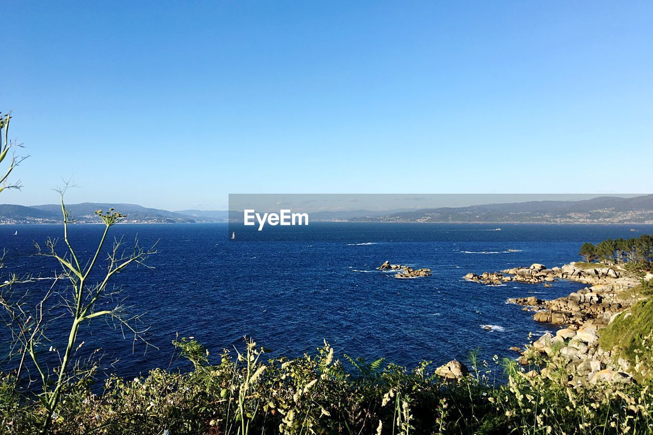 Scenic view of sea against clear blue sky