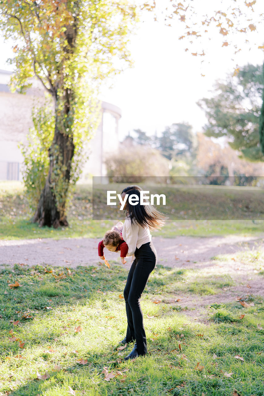 side view of young woman standing on grassy field