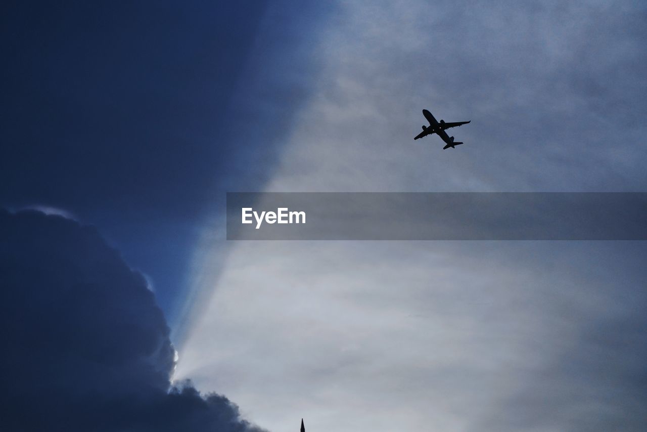 Low angle view of silhouette airplane against sky