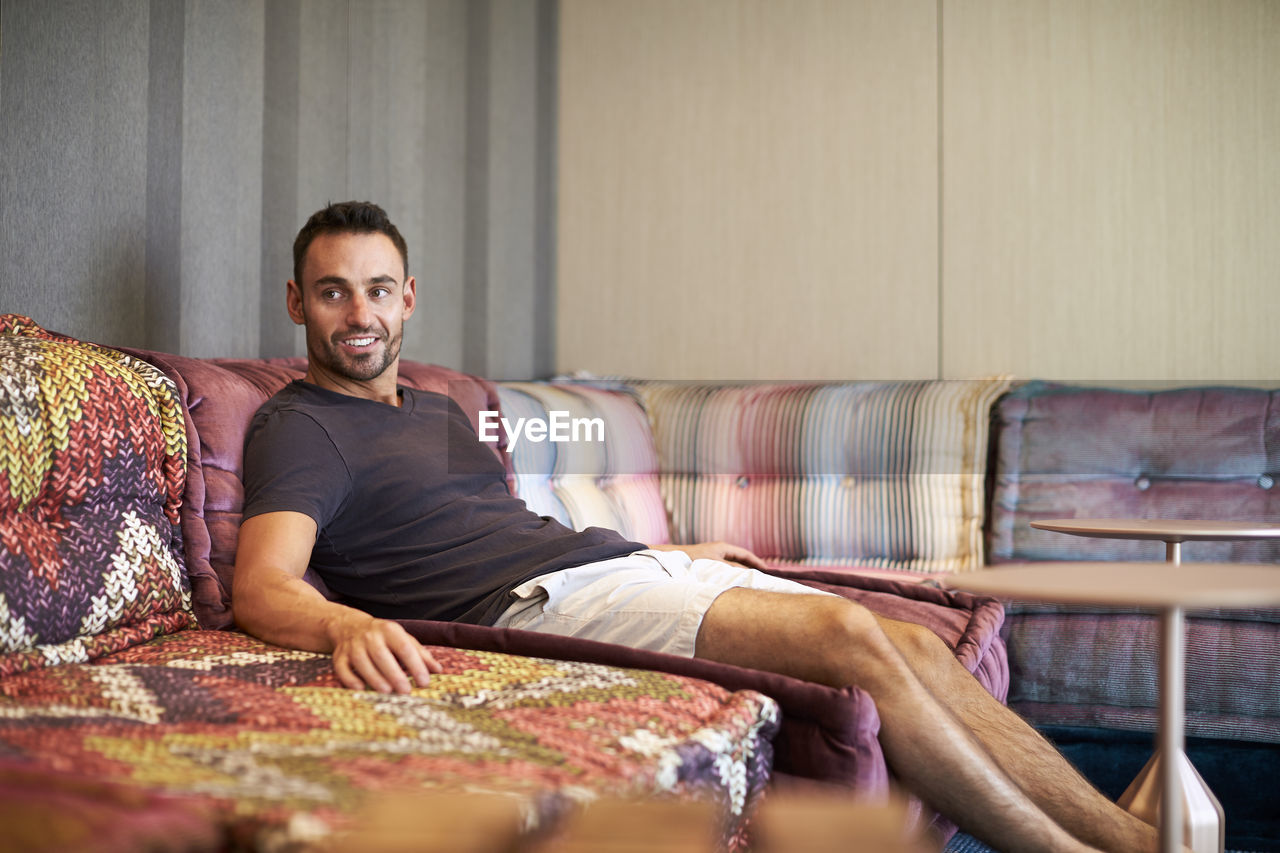 A man relaxes on a comfortable modern couch.