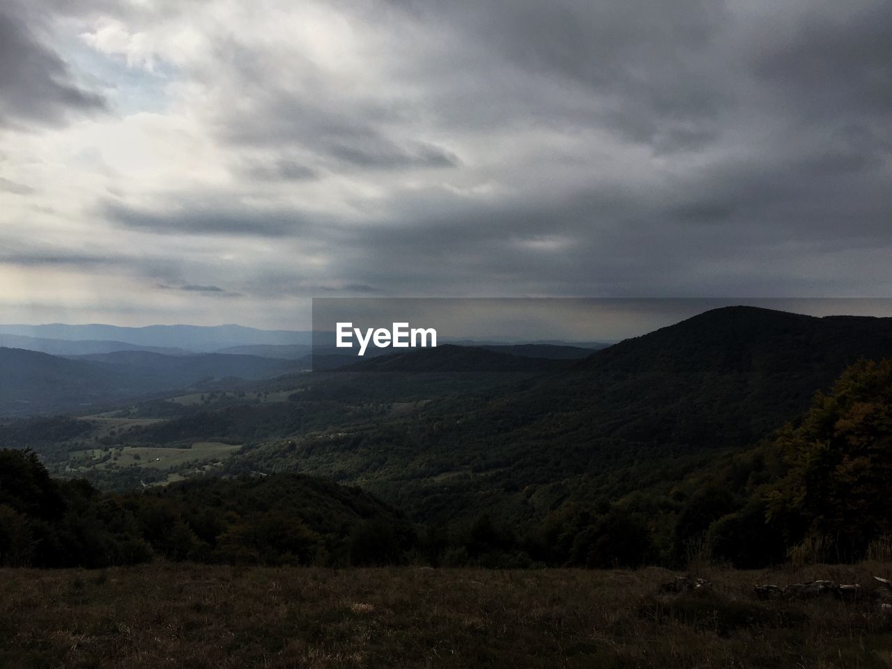 Silhouette mountains against cloudy sky