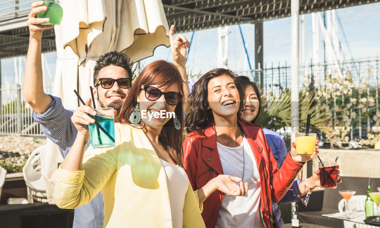 Portrait of cheerful friends enjoying party at beach