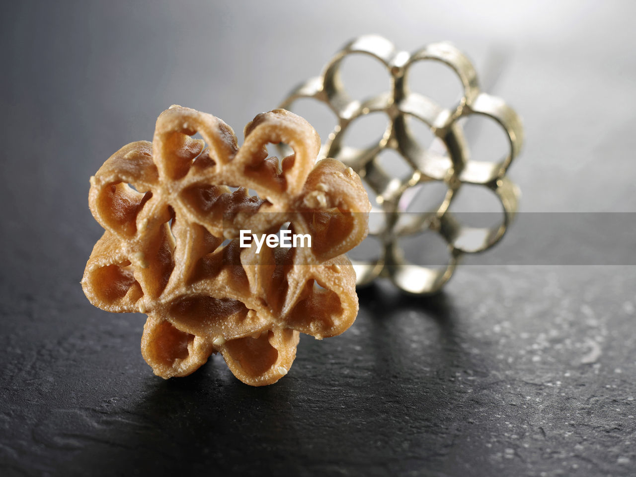 Close-up of rose cookie and pastry cutter on table