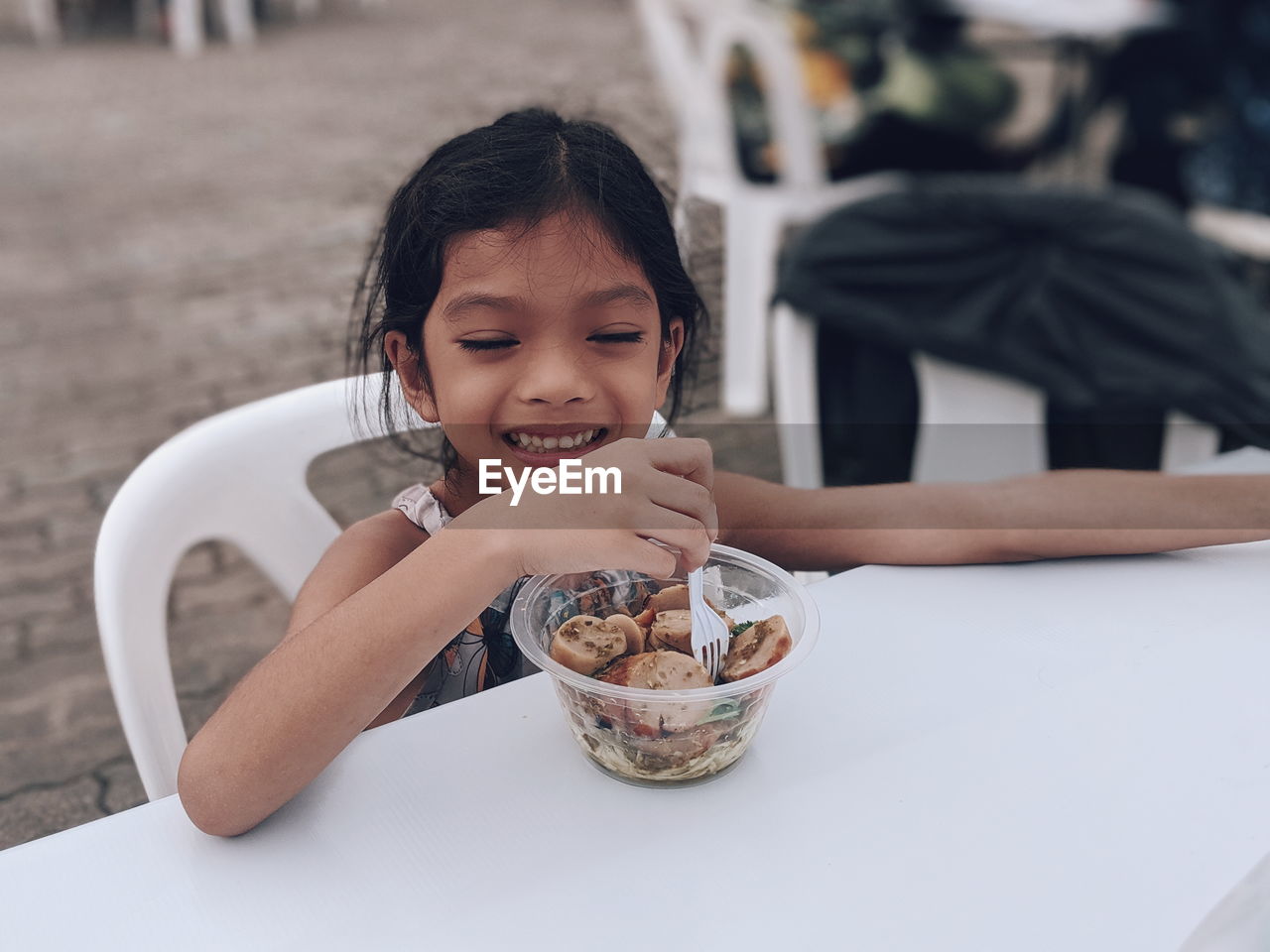 Smiling girl eating on table