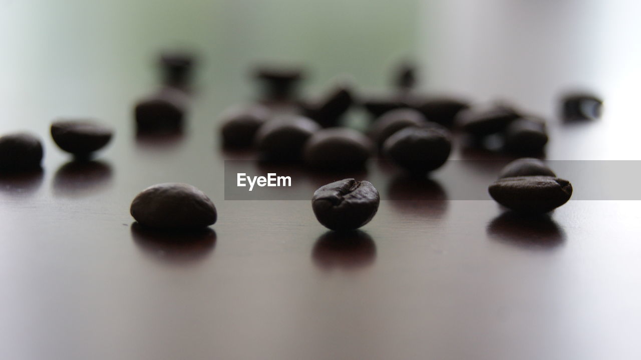 CLOSE-UP OF COFFEE BEANS IN GLASS ON TABLE
