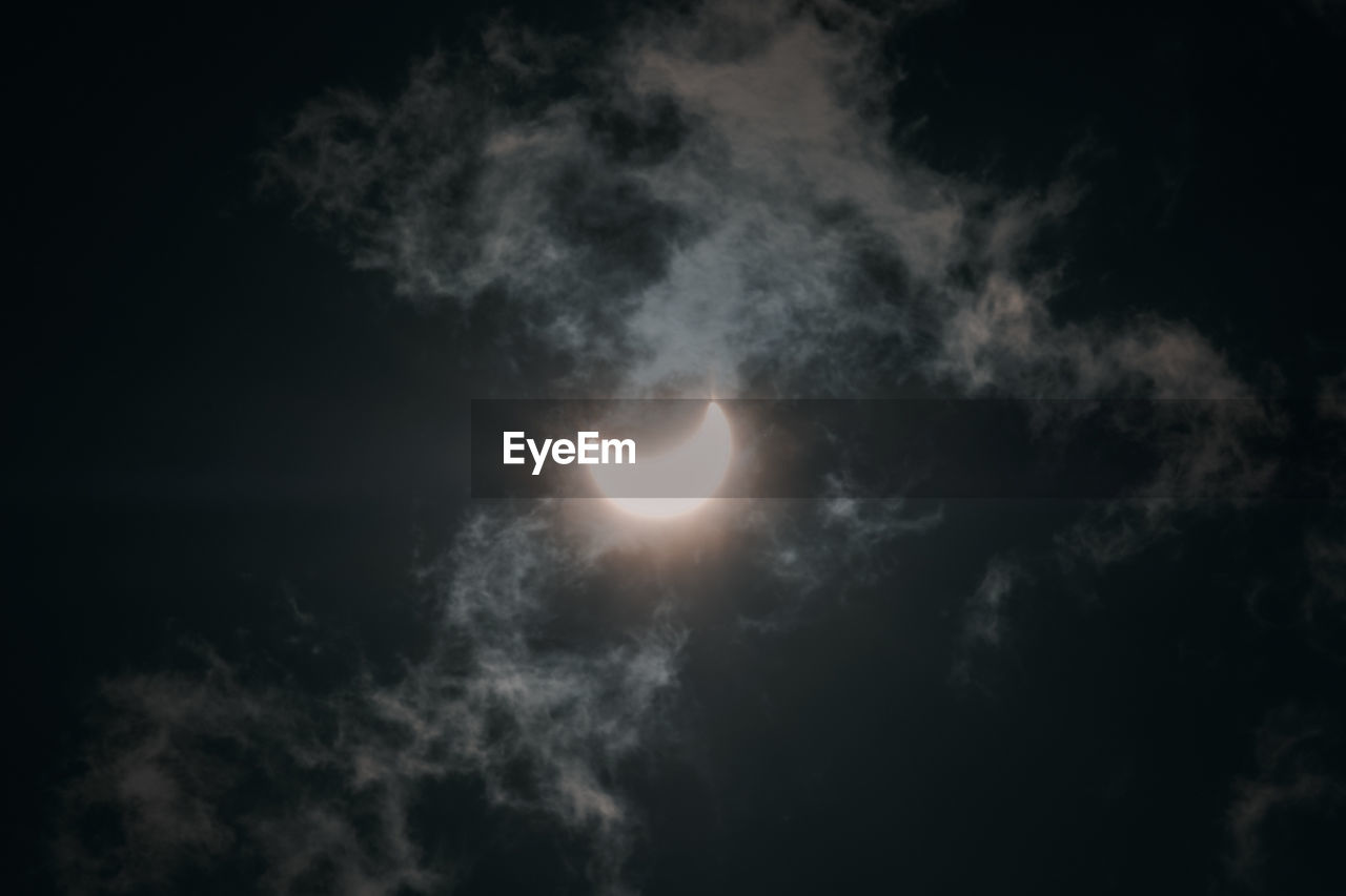 LOW ANGLE VIEW OF MOON AGAINST CLOUDY SKY