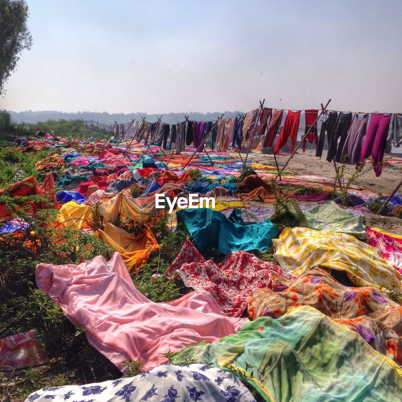 Multi colored clothes drying below the clear sky