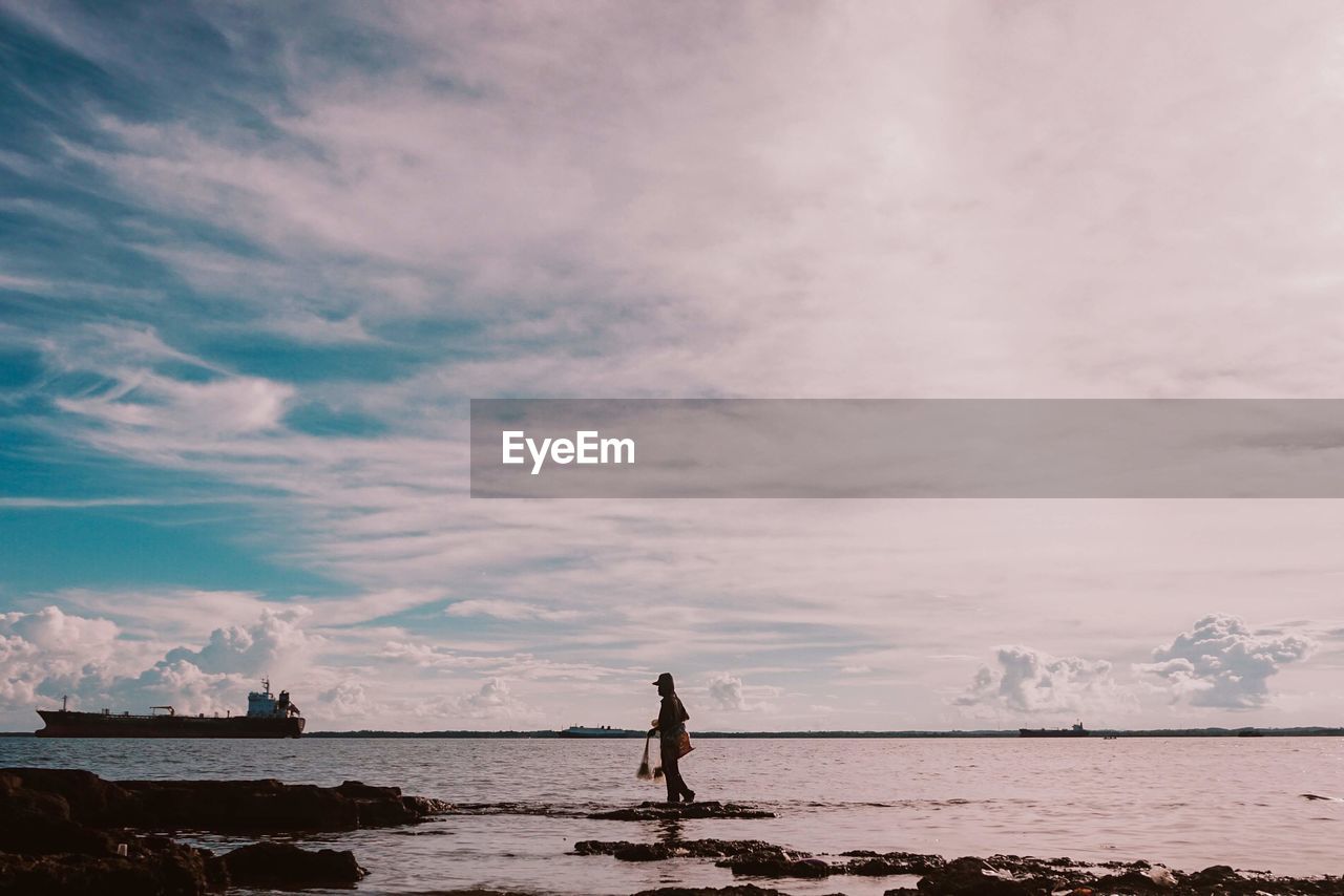 PERSON ON BEACH AGAINST SKY