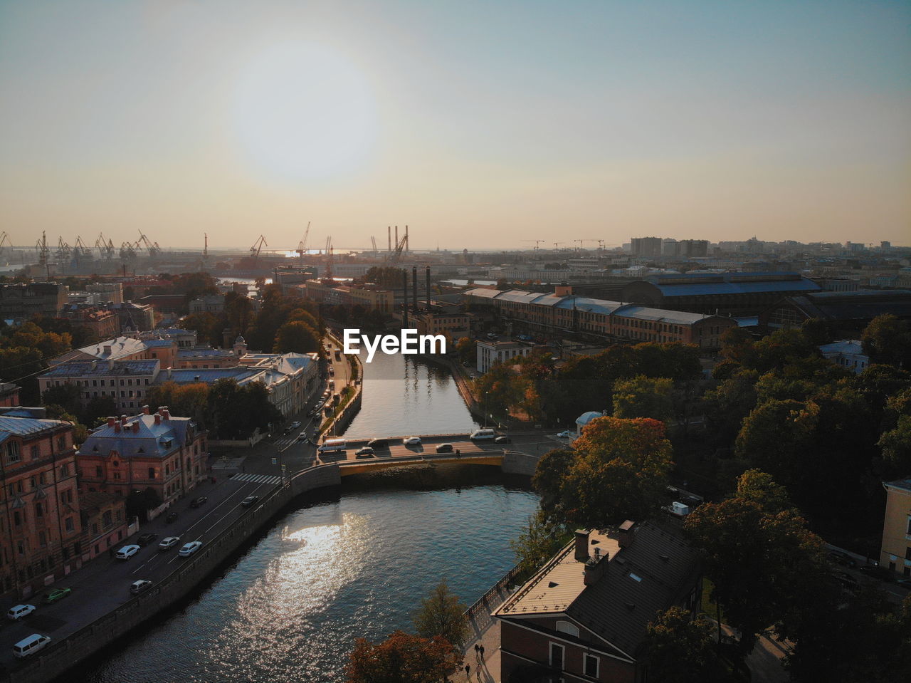 High angle view of river amidst buildings against sky during sunset