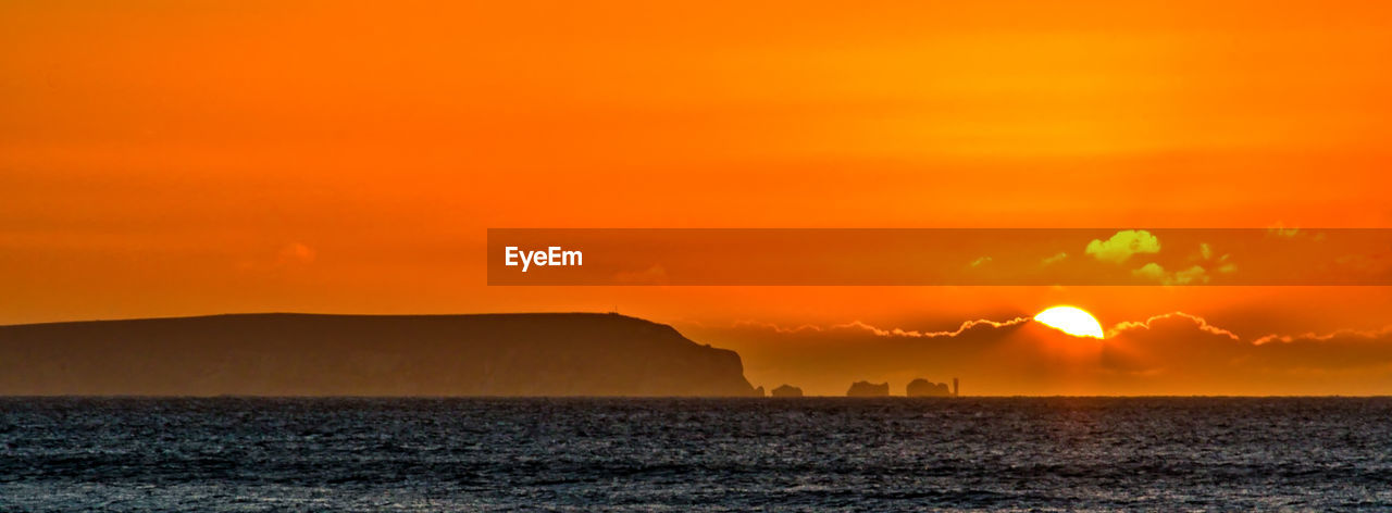 Scenic view of dramatic sky over sea during sunset