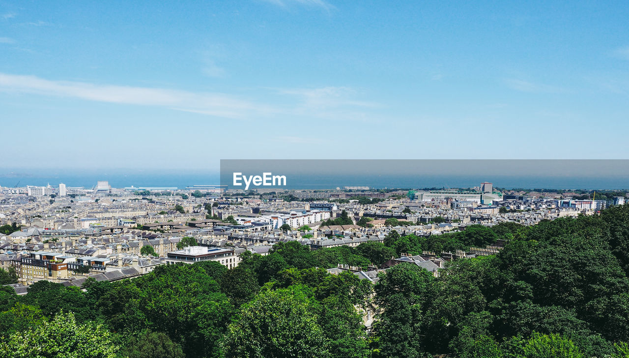 High angle view of townscape by sea against sky