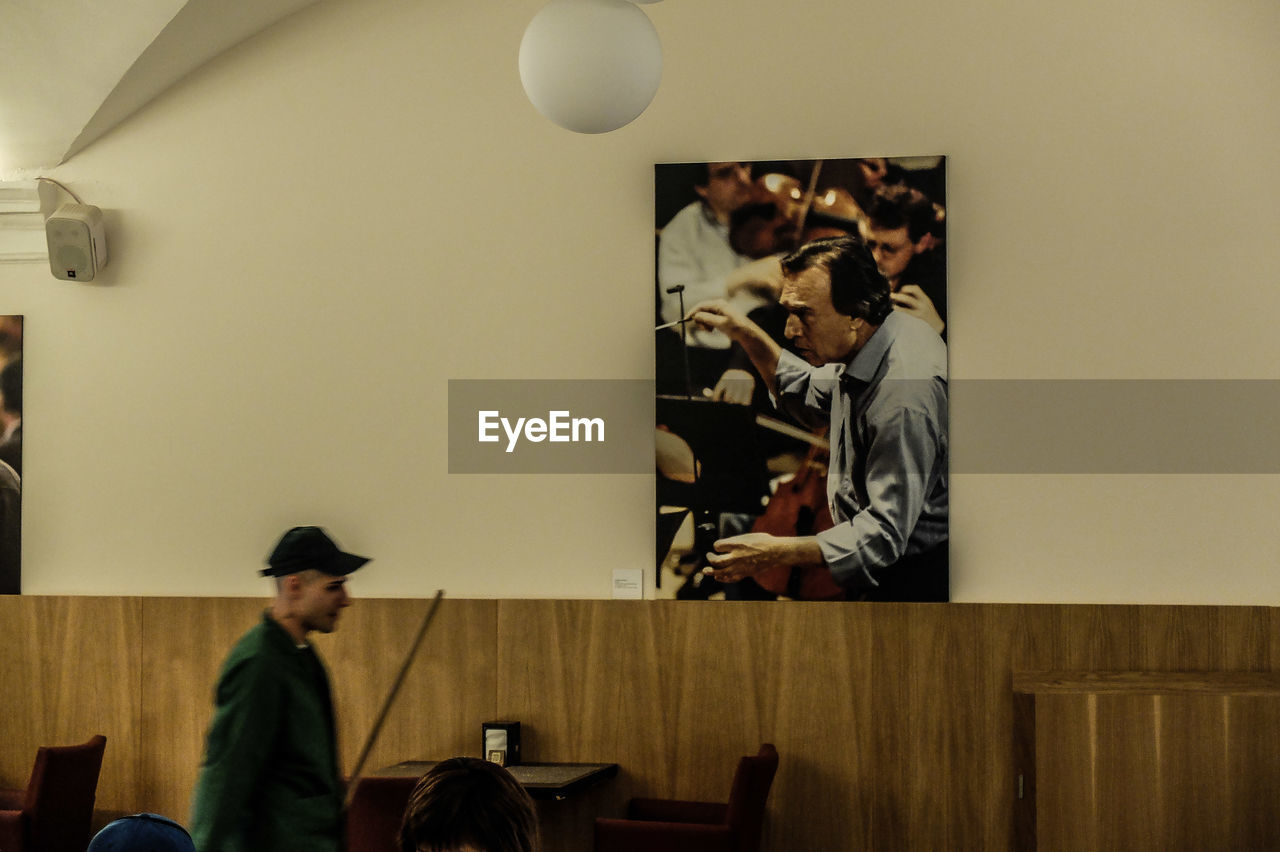 PEOPLE SITTING AT TABLE BY WALL