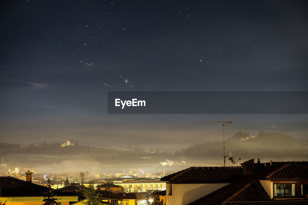 Illuminated cityscape against sky at night