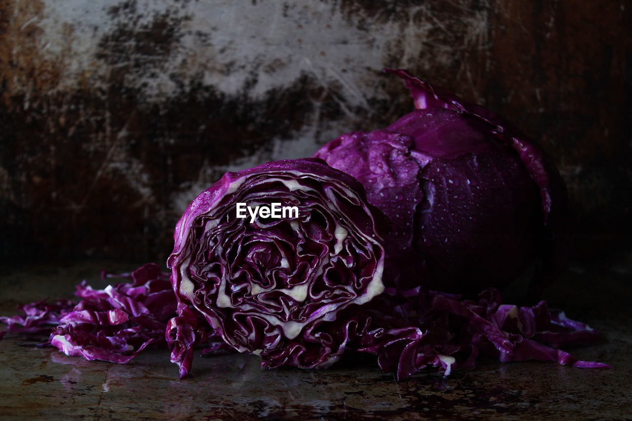 CLOSE-UP OF PURPLE FLOWERS IN CONTAINER ON TABLE