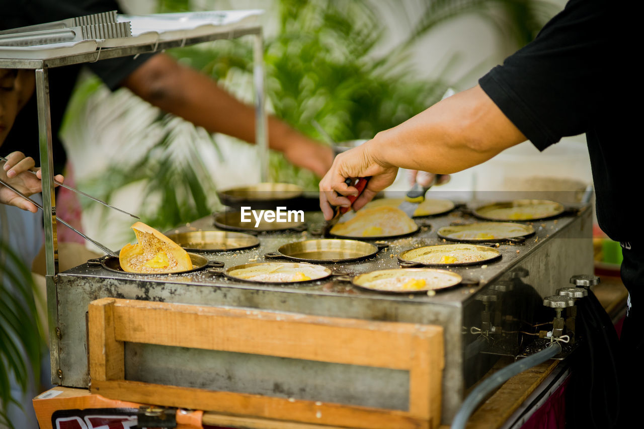 Midsection of person preparing food, malaysian snacks known as apam balik.