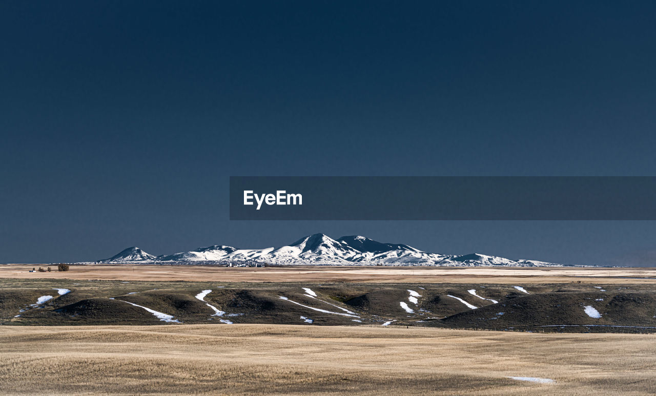 Scenic view of snowcapped mountains against clear sky during winter