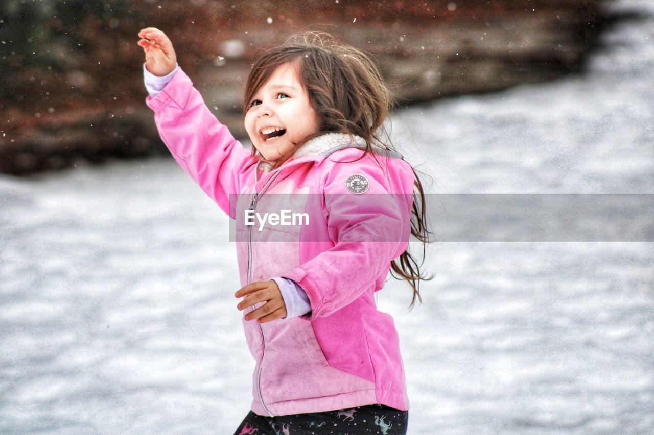 Portrait of smiling young girl playing in snow