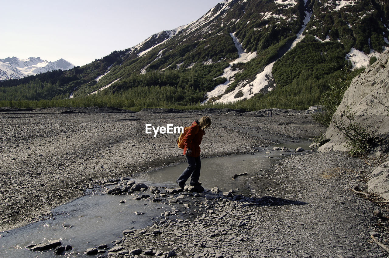 FULL LENGTH REAR VIEW OF MAN WALKING ON MOUNTAIN