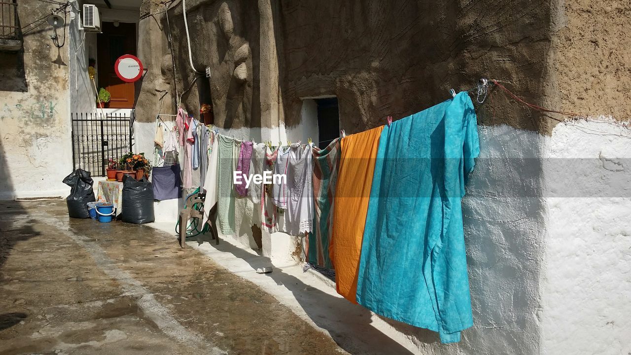 Clothesline against house in town on sunny day