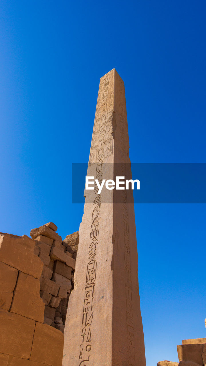 low angle view of rock formations against clear blue sky