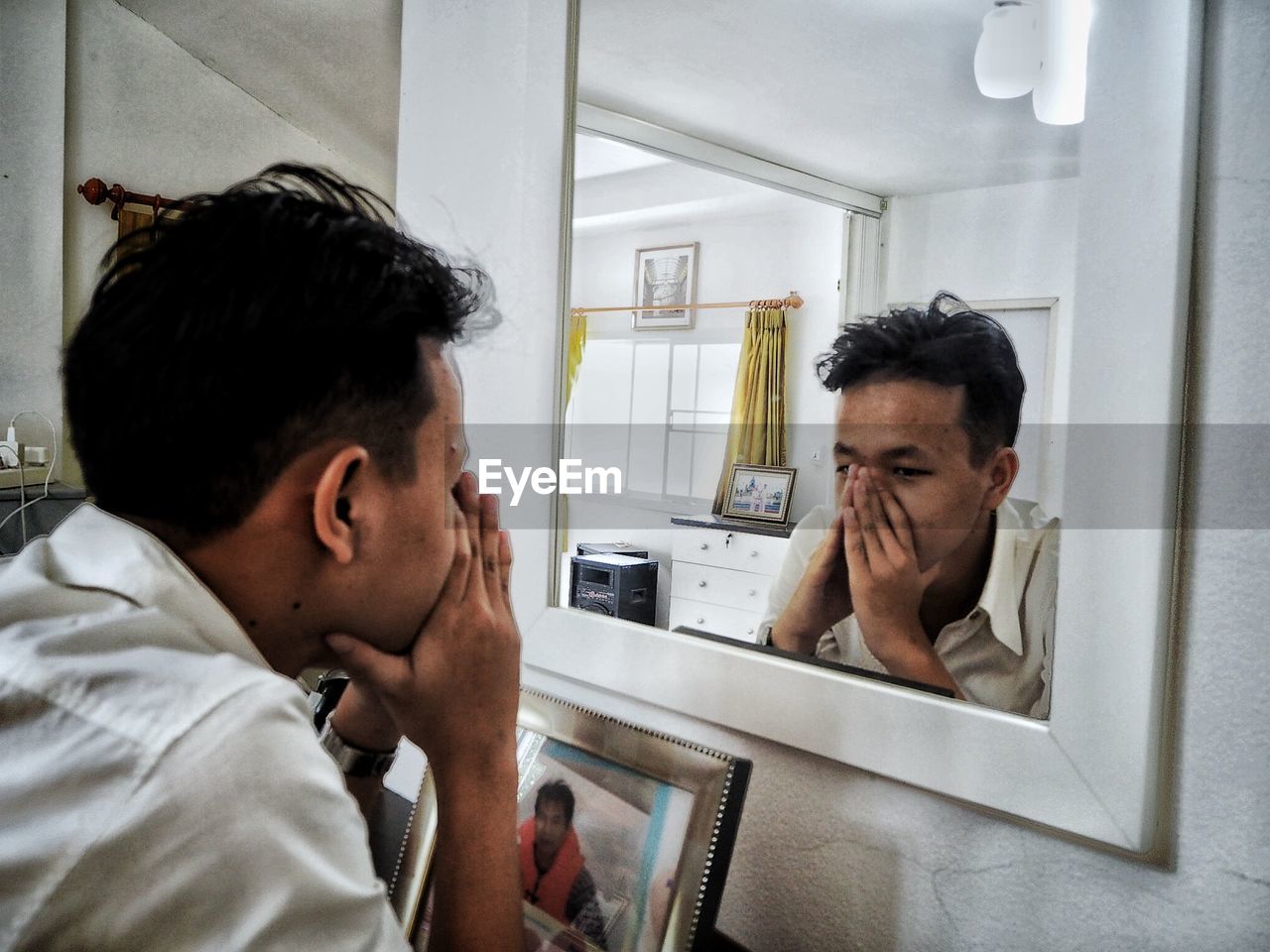 Depressed man looking in mirror