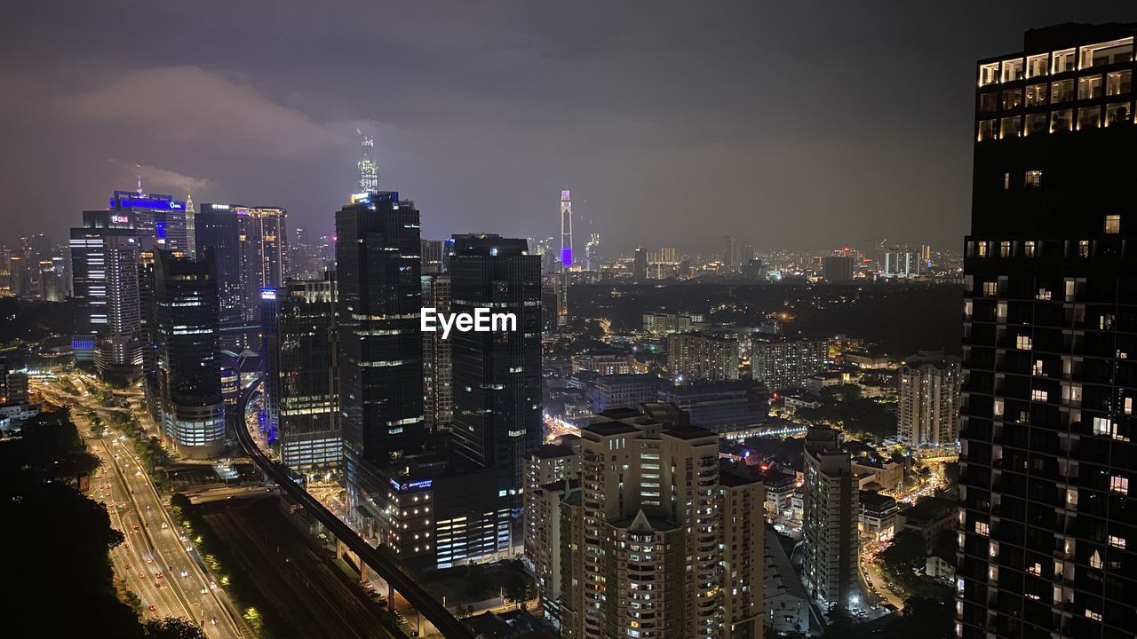 Illuminated cityscape against sky at night