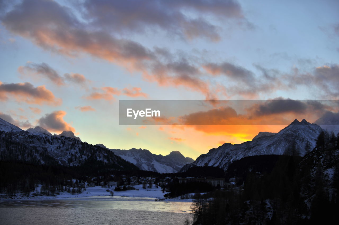 Scenic view of snowcapped mountains against sky during sunset