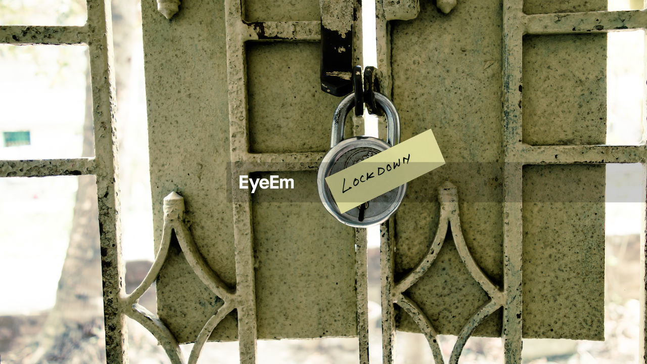 Close-up of information sign hanging on padlocks. covid lockdown corona virus themes