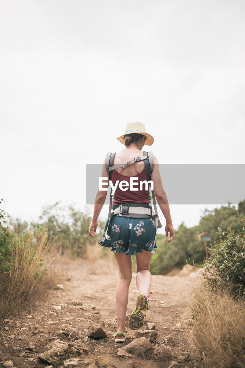 Rear view of woman walking on field