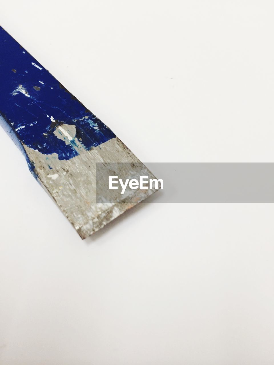 Close-up of paint scraper against white background