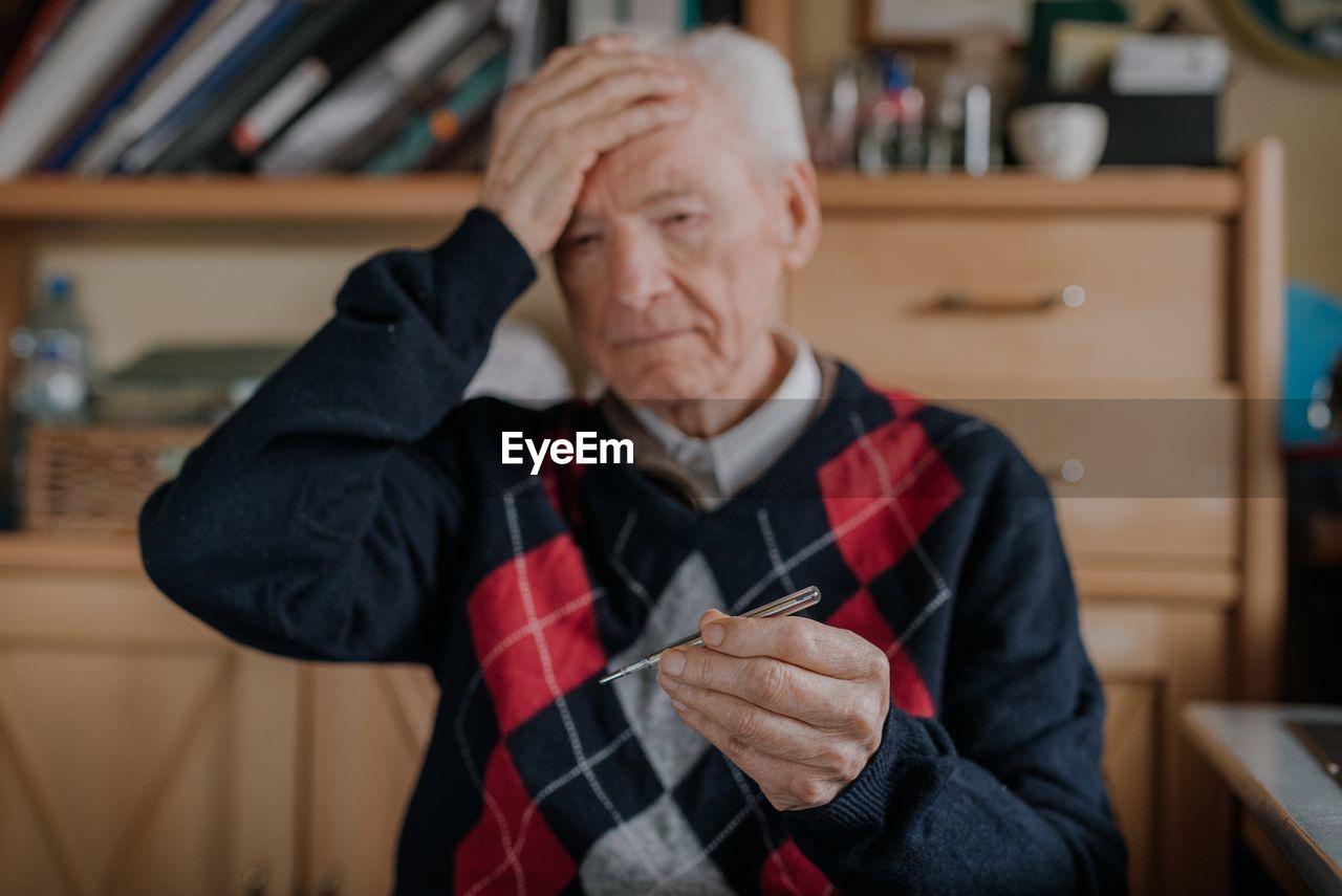 Midsection of man holding while sitting at home