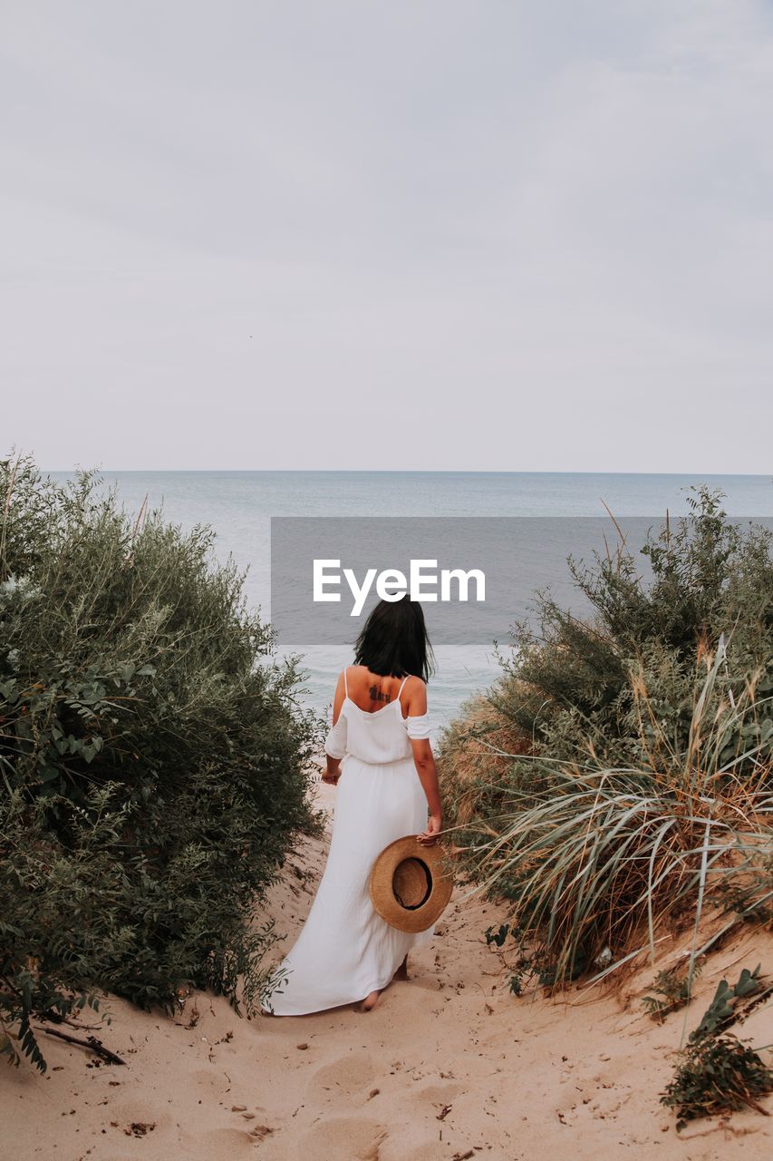 Woman looking at sea against sky