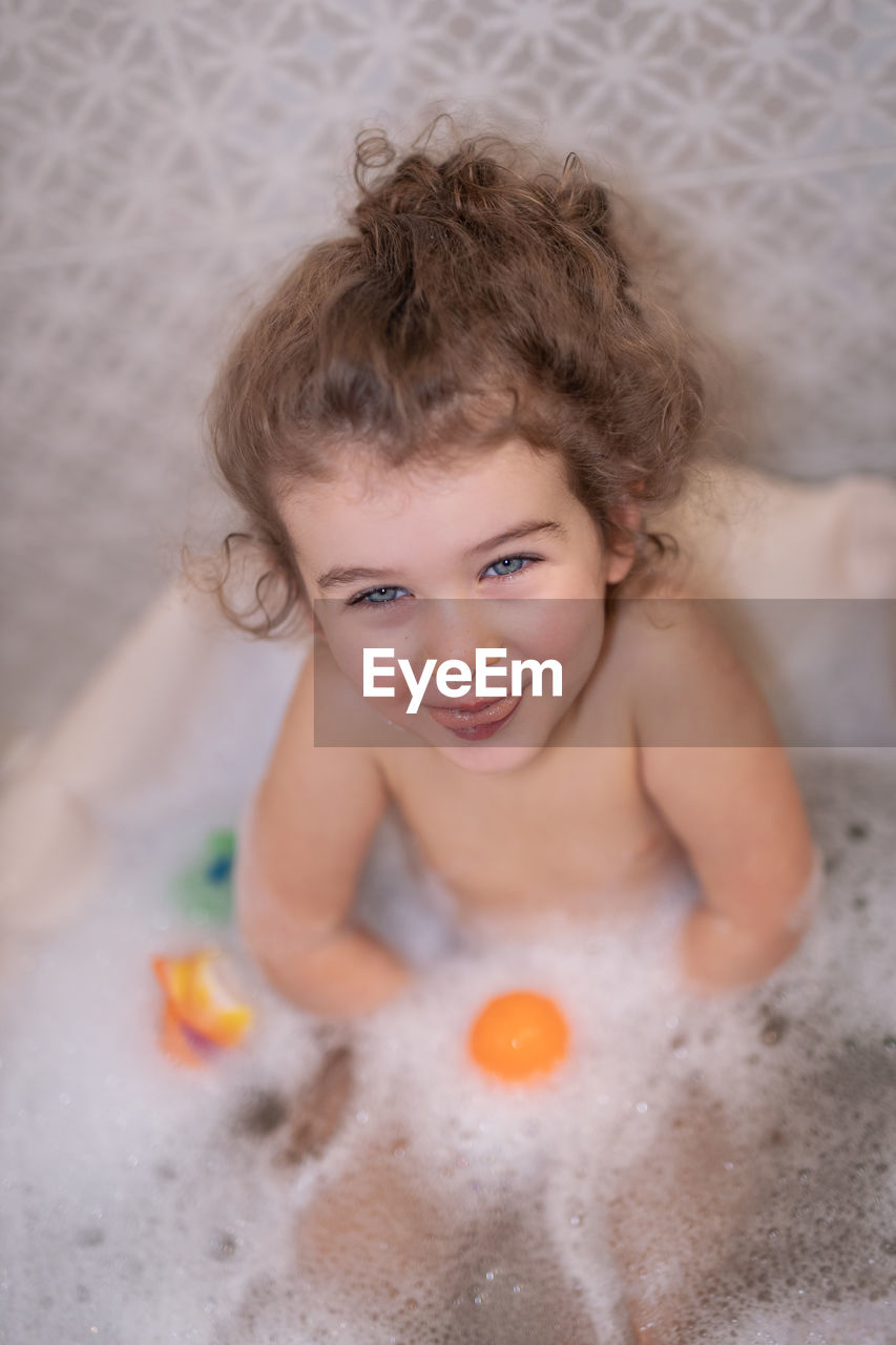 HIGH ANGLE PORTRAIT OF BOY IN BATHROOM