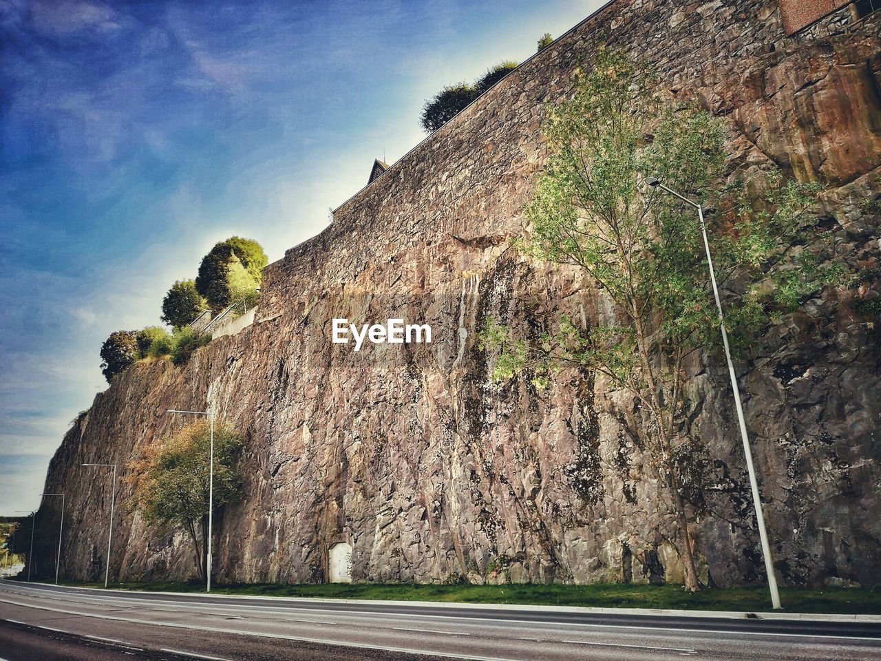 ROAD BY ROCK AGAINST SKY