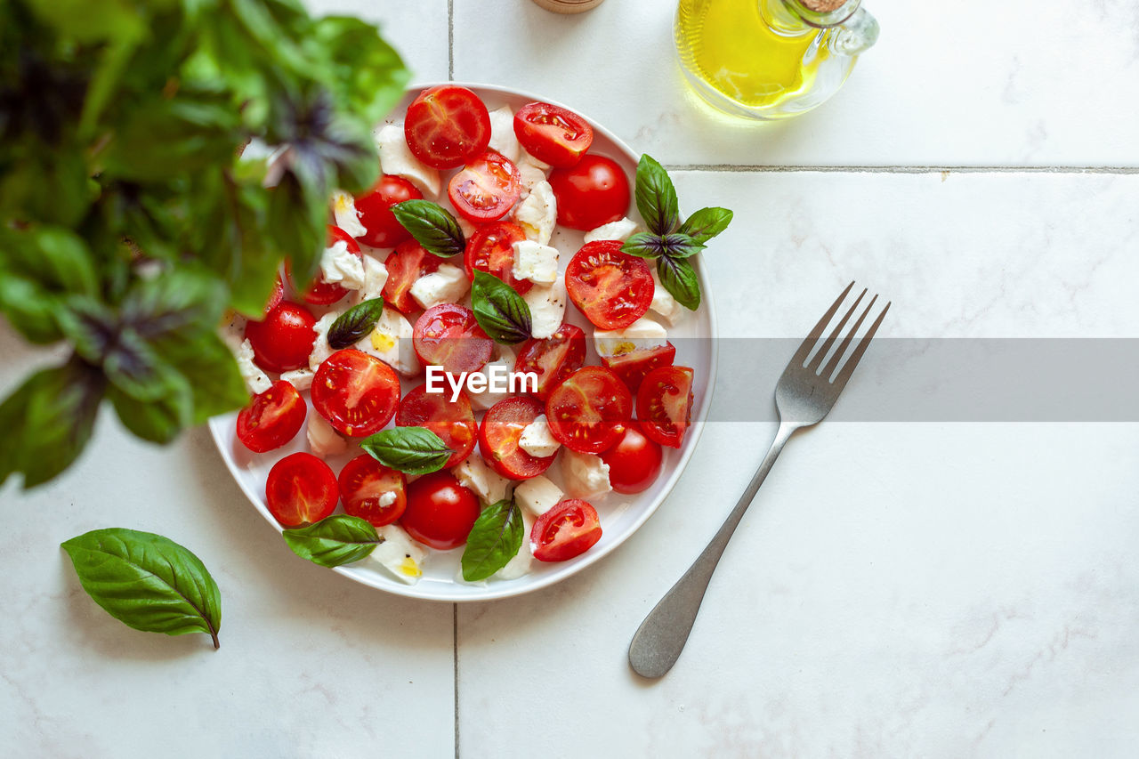 food and drink, food, healthy eating, fruit, freshness, wellbeing, plant, vegetable, produce, eating utensil, kitchen utensil, tomato, fork, high angle view, red, herb, no people, plate, indoors, household equipment, salad, wood, crockery, dish, italian food, table, bowl, vegetarian food, meal, nature, spice, studio shot, leaf