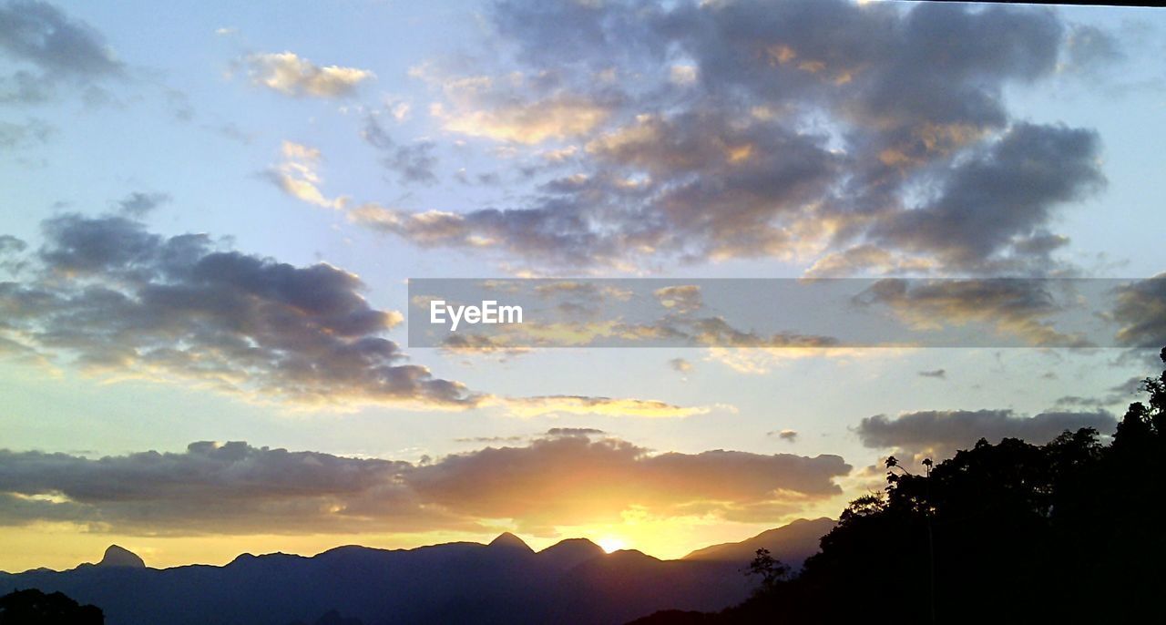 SCENIC VIEW OF MOUNTAINS AT SUNSET