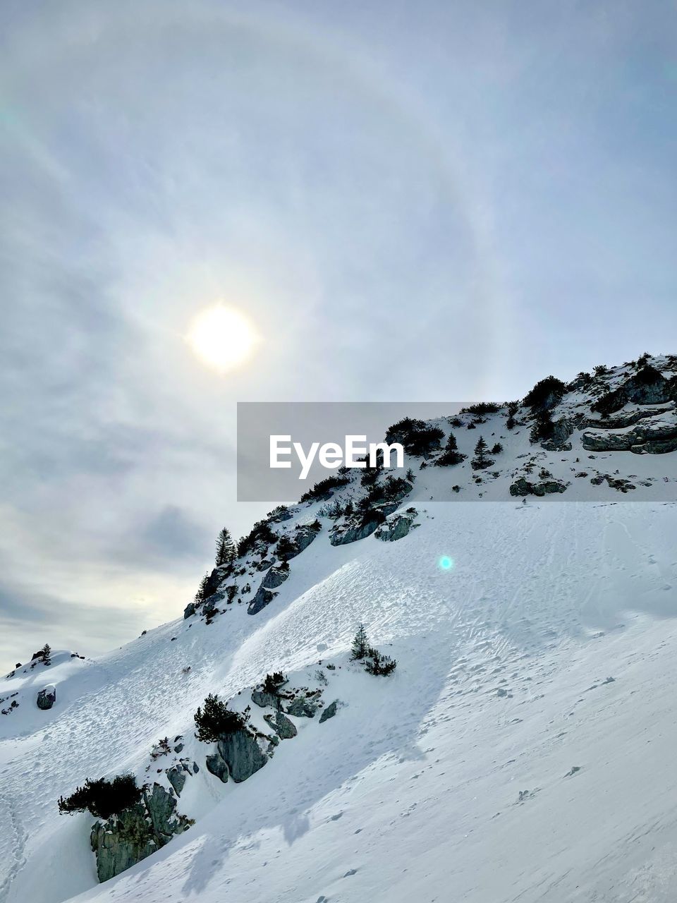 SCENIC VIEW OF SNOW COVERED MOUNTAINS AGAINST BRIGHT SUN